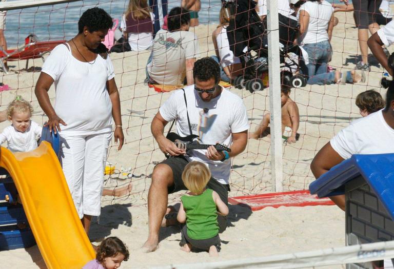 Carlos Bonow e o filho, Conrado, brincam na praia do Leblon, no Rio de Janeiro