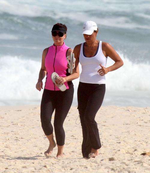 Giovanna Antonelli corre ao lado de amiga na praia da Barra da Tijuca
