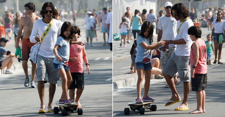 O ator André Gonçalves ensina os filhos a andar de skate na orla carioca