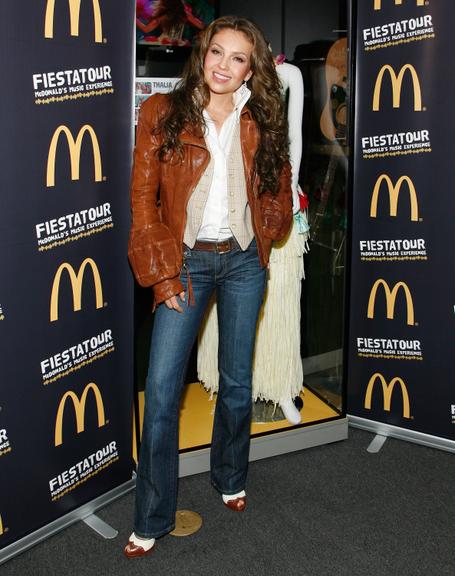 Thalía veste calça jeans, camisa e jaqueta de couro com manga exótica