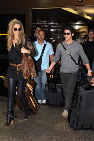 Nick Jonas desembarca no aeroporto com a namorada, a cantora Delta Goodrem