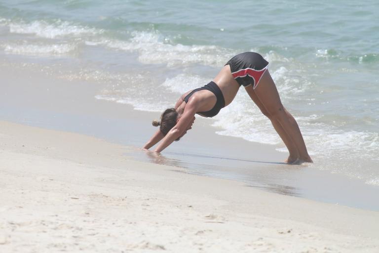 Juliana Didone faz alongamento na praia da Barra da Tijuca