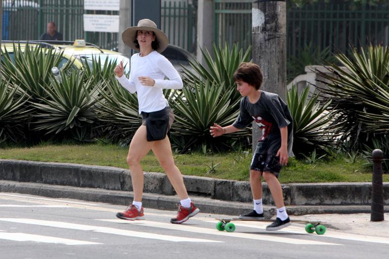 Fernanda Torres pratica exercícios enquanto o filho mais velho, Joaquim, a acompanha de skate