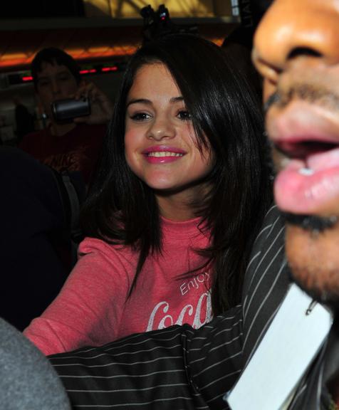 Selena Gomez aparece sorridente no aeroporto de Los Angeles