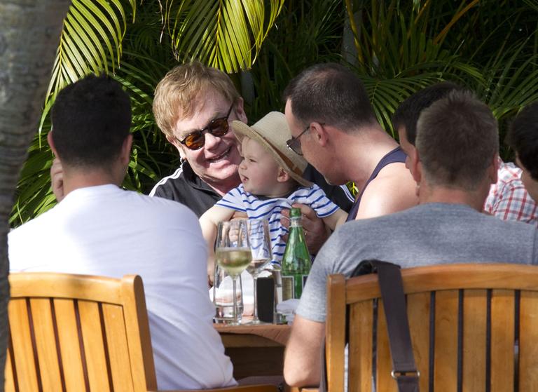 Elton John brinca com o filho, Zachary, durante almoço no Hawai