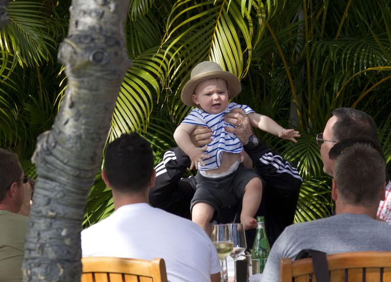 Elton John brinca com o filho, Zachary, durante almoço no Hawai