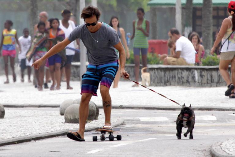 Paulinho Vilhena anda de skate com seu cachorro no Rio de Janeiro