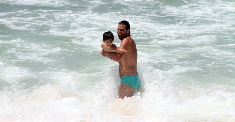 Henri Castelli brinca com o filho, Lucas, na praia