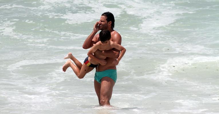 Henri Castelli brinca com o filho, Lucas, na praia