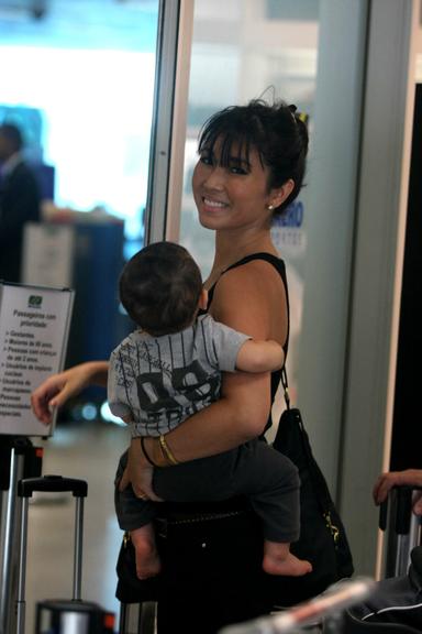 Com o pequeno Kauai, Daniele Suzuki sorri no aeroporto Santos Dummont