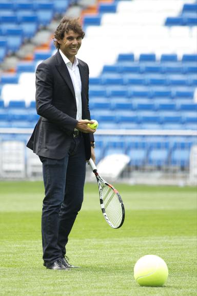 De terno e sapato, Rafael Nadal joga tênis no campo do Real Madrid