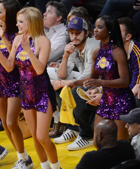 Ator Ashton Kutcher observa dançarinas em jogo dos Lakers em Los Angeles