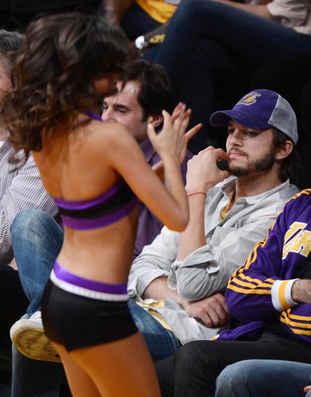 Ator Ashton Kutcher observa dançarinas em jogo dos Lakers em Los Angeles