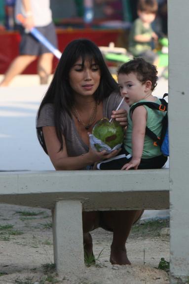 Daniele Suzuki dá água de coco para o filho, o pequeno Kauai