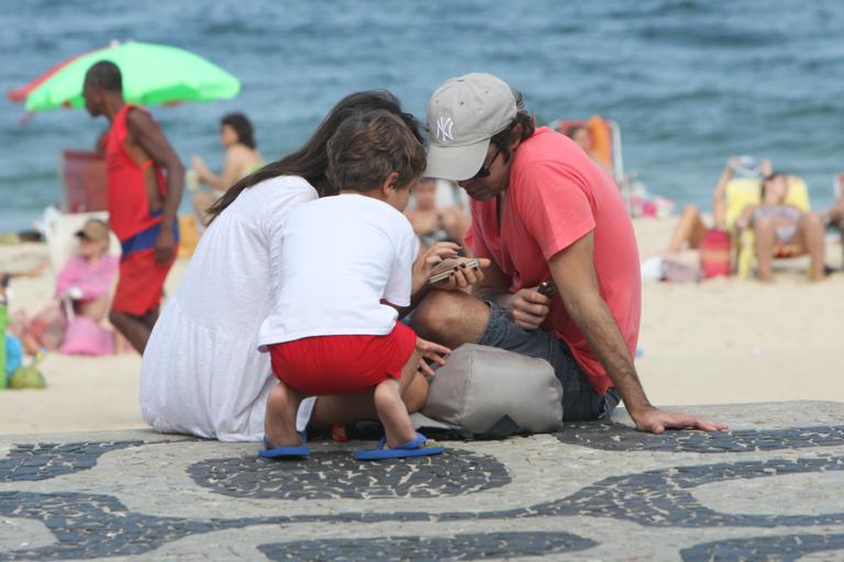 Bruno Mazzeo curte praia do Leblon com morena e filho, João 