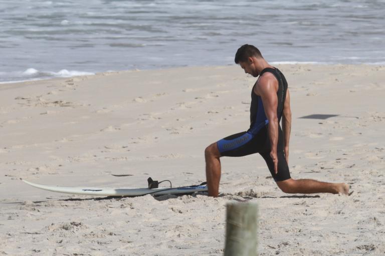 Cauã Reymond se alonga antes do surfe