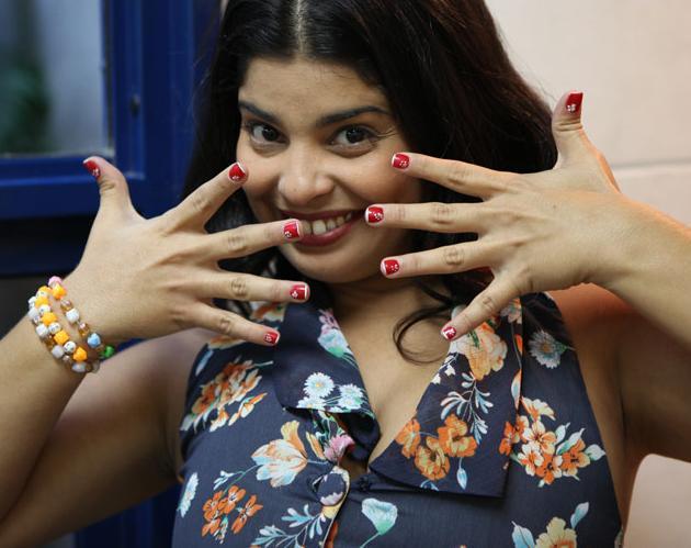 Gracinha (Daniela Fontan) gosta de criar em suas unhas, como o esmalte vermelho com francesinha e flores brancas