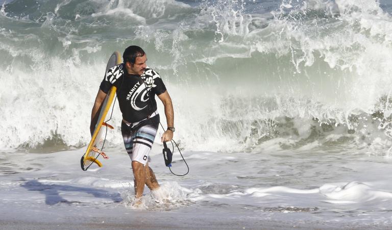 Humberto Martins surfa na praia no Recreio 