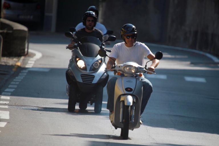 George Clooney passeia de scooter com amigos pela Itália