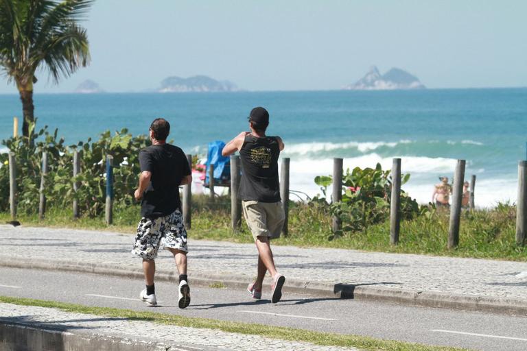 André Gonçalves se exercita pela orla da praia do Recreio, Rio de Janeiro