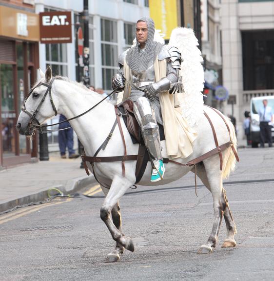 Robbie Williams aparece como um cavaleiro de asas na ruas de Londres