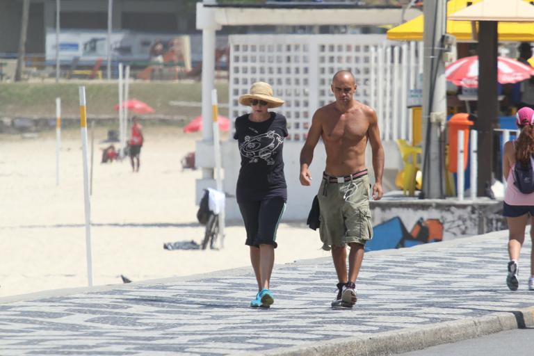 Betty Lago caminha na praia do Leblon com o filho