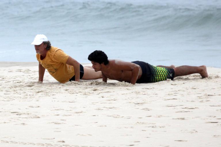 Marcello Novaes se exercita com o filho Diogo, na praia da Barra