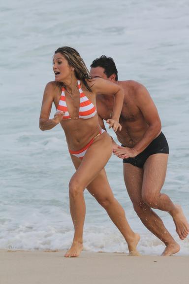 Flávia Alessandra e Rodrigo Lombardi gravam cenas de amor na praia