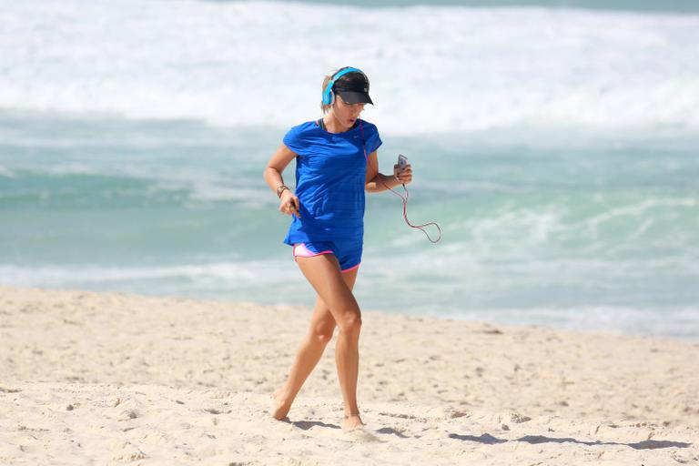 Grazi Massafera esbanja boa forma durante corrida na praia
