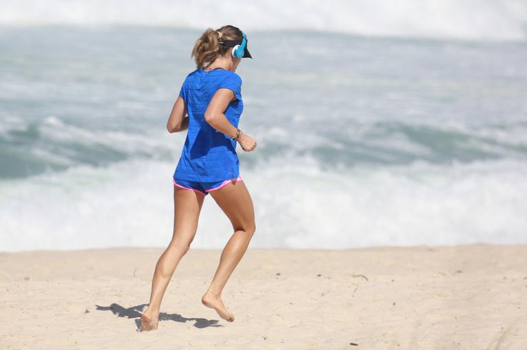 Grazi Massafera esbanja boa forma durante corrida na praia