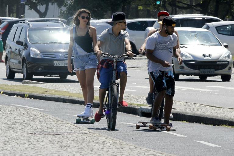 Bruna Marquezine anda de skate com amigos na orla de praia no Rio