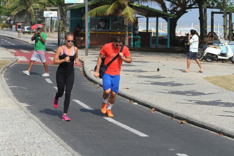 Enzo Celulari corre com a namorada em orla da praia no Rio