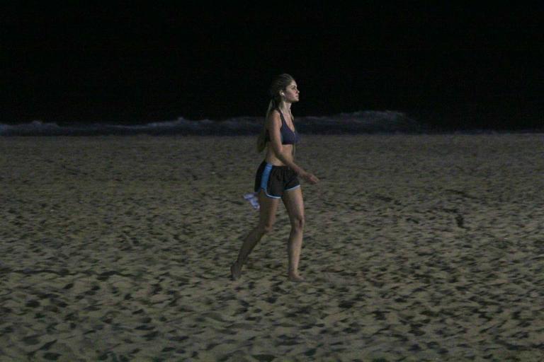 Bárbara Evans corre na praia durante a noite e mostra boa forma