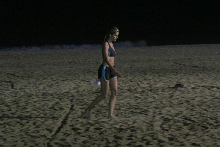 Bárbara Evans corre na praia durante a noite e mostra boa forma