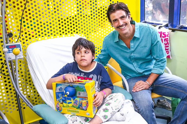 Reynaldo Gianecchini visita crianças, distribui presentes e tira fotos no hospital do GRAAC
