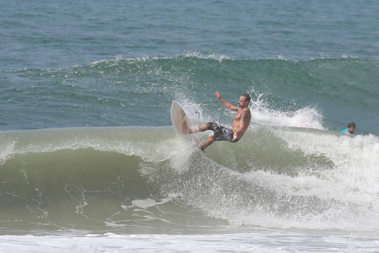 Paulinho Vilhena exibe corpo sarado em dia surfe