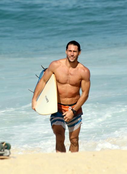 Flávio Canto exibe tanquinho em dia de surfe na praia