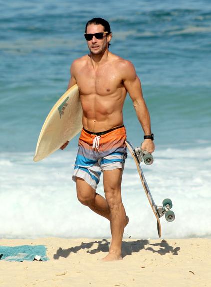 Flávio Canto exibe tanquinho em dia de surfe na praia