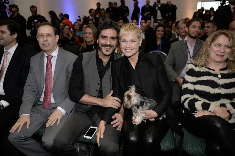 Xuxa e Junno Andrade levam cachorrinho em evento empresarial 