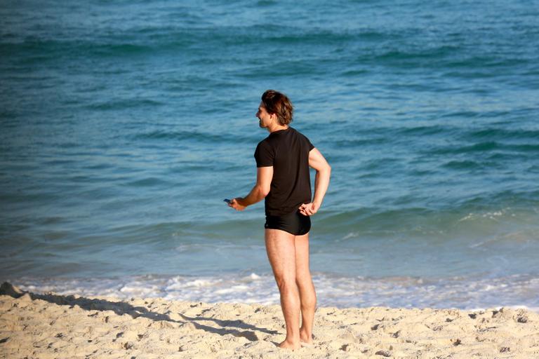 Sem desgrudar do celular, Murilo Rosa curte dia de praia no Rio de Janeiro