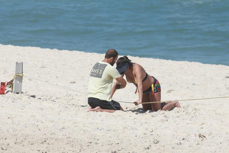 Deborah Secco exibe barrigão durante treino na praia