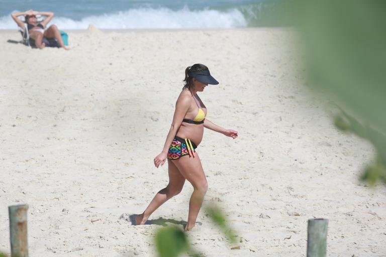 Deborah Secco exibe barrigão durante treino na praia