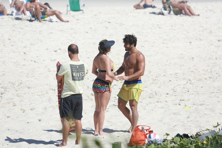 Deborah Secco recebe o carinho de Hugo Moura durante malhação na praia