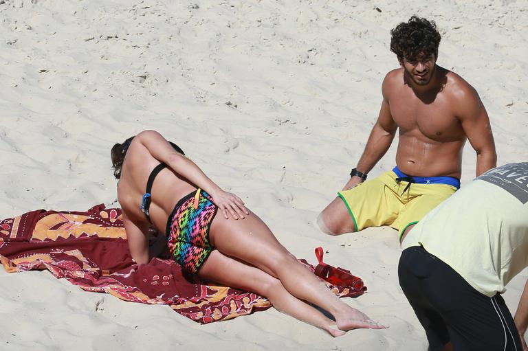 Deborah Secco recebe o carinho de Hugo Moura durante malhação na praia