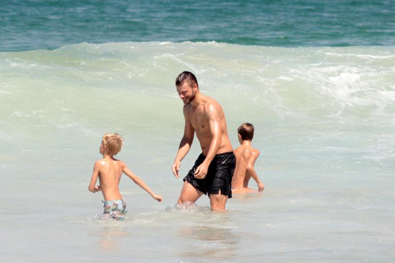 Rodrigo Hilbert curte dia na praia com os filhos gêmeos