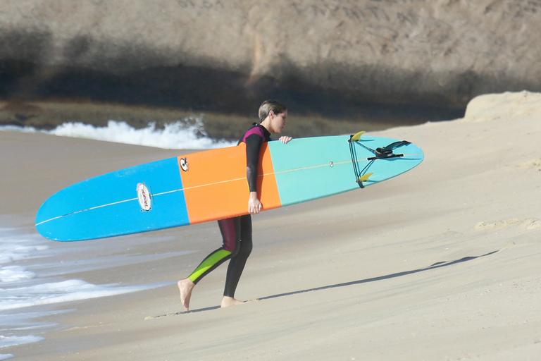 Isabella Santoni segura a prancha após aula de surfe em praia no Rio