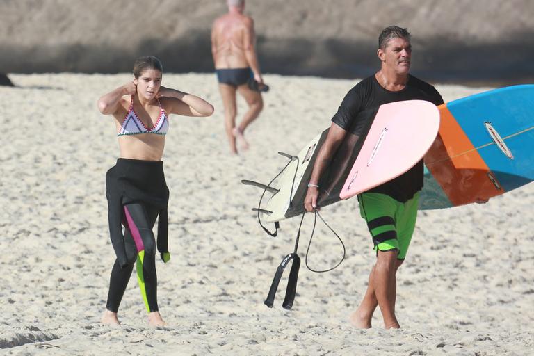 Isabella Santoni e professor deixam a praia após aula de surfe