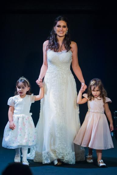 Ex- Miss Natália Guimarães desfila com as filhas gêmeas