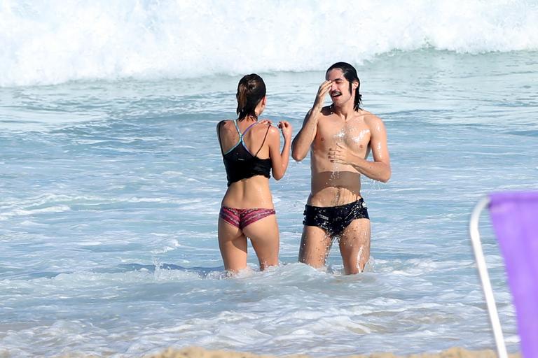 Gabriel Leone e Carla Salle trocam beijos na praia