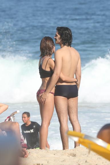 Gabriel Leone e Carla Salle trocam beijos na praia